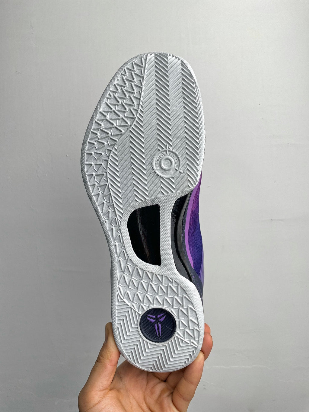 White rubber outsole with traction tread and purple/gray upper detail