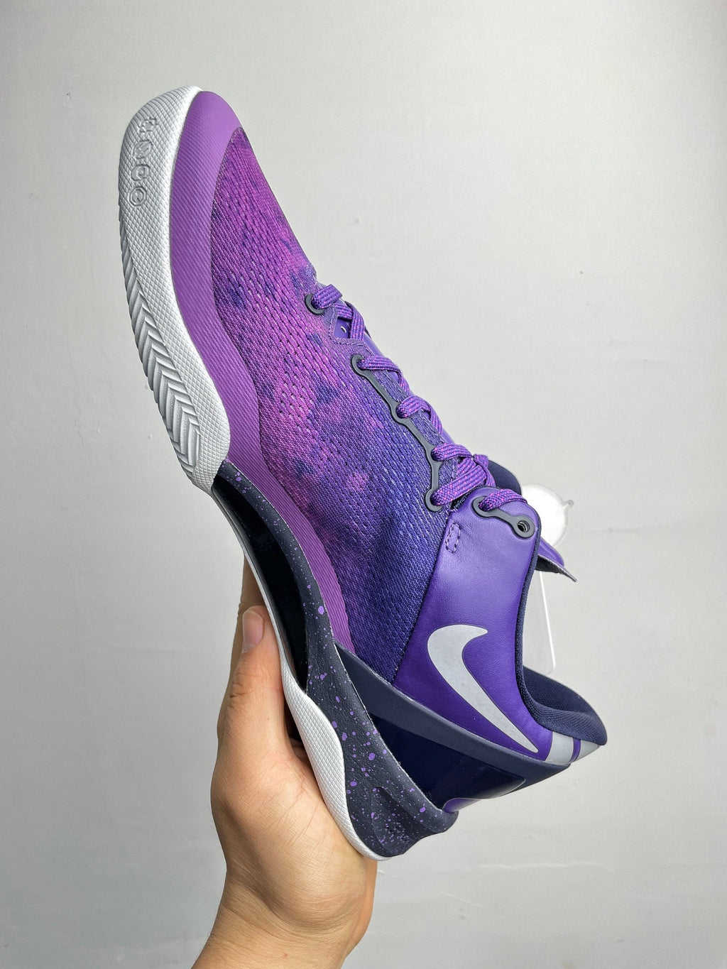 Purple basketball shoe with white midsole, side Nike swoosh, and lace-up design