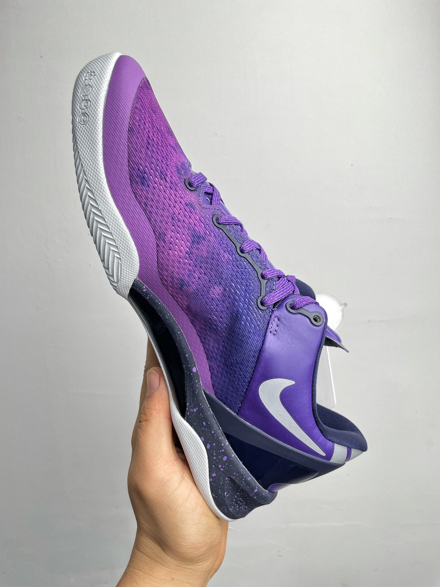 Purple basketball shoe with white midsole, side Nike swoosh, and lace-up design