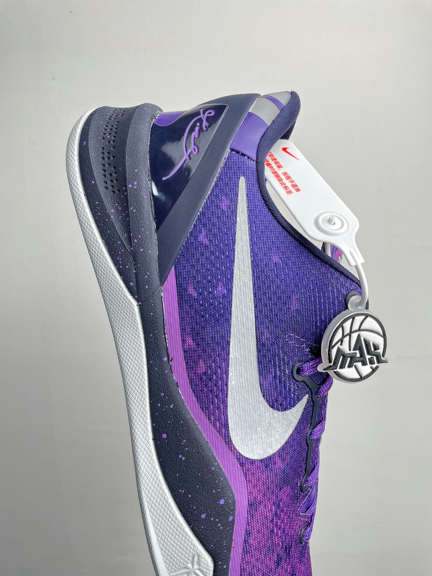 Purple and dark navy basketball shoe with white side swoosh and textured upper