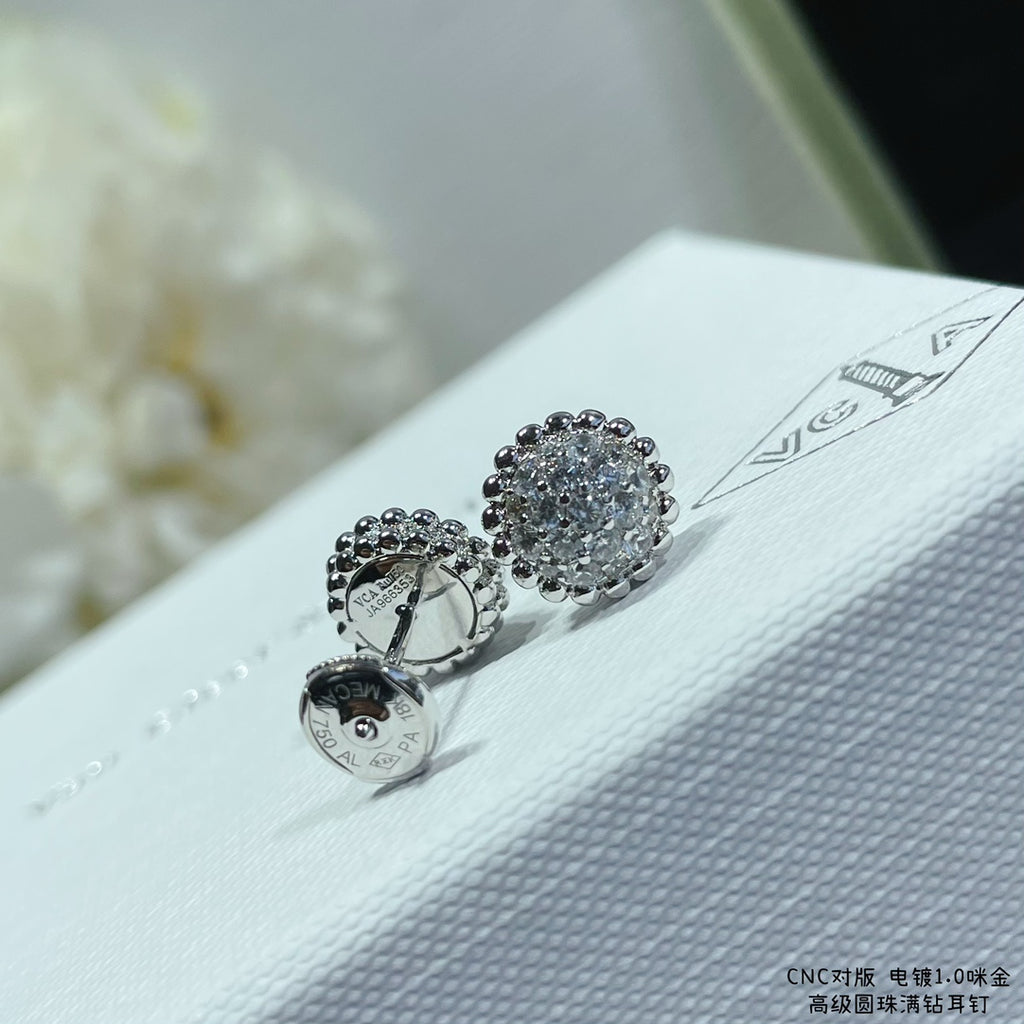 Round pavé stud earrings in silver-toned metal on a white jewelry pouch