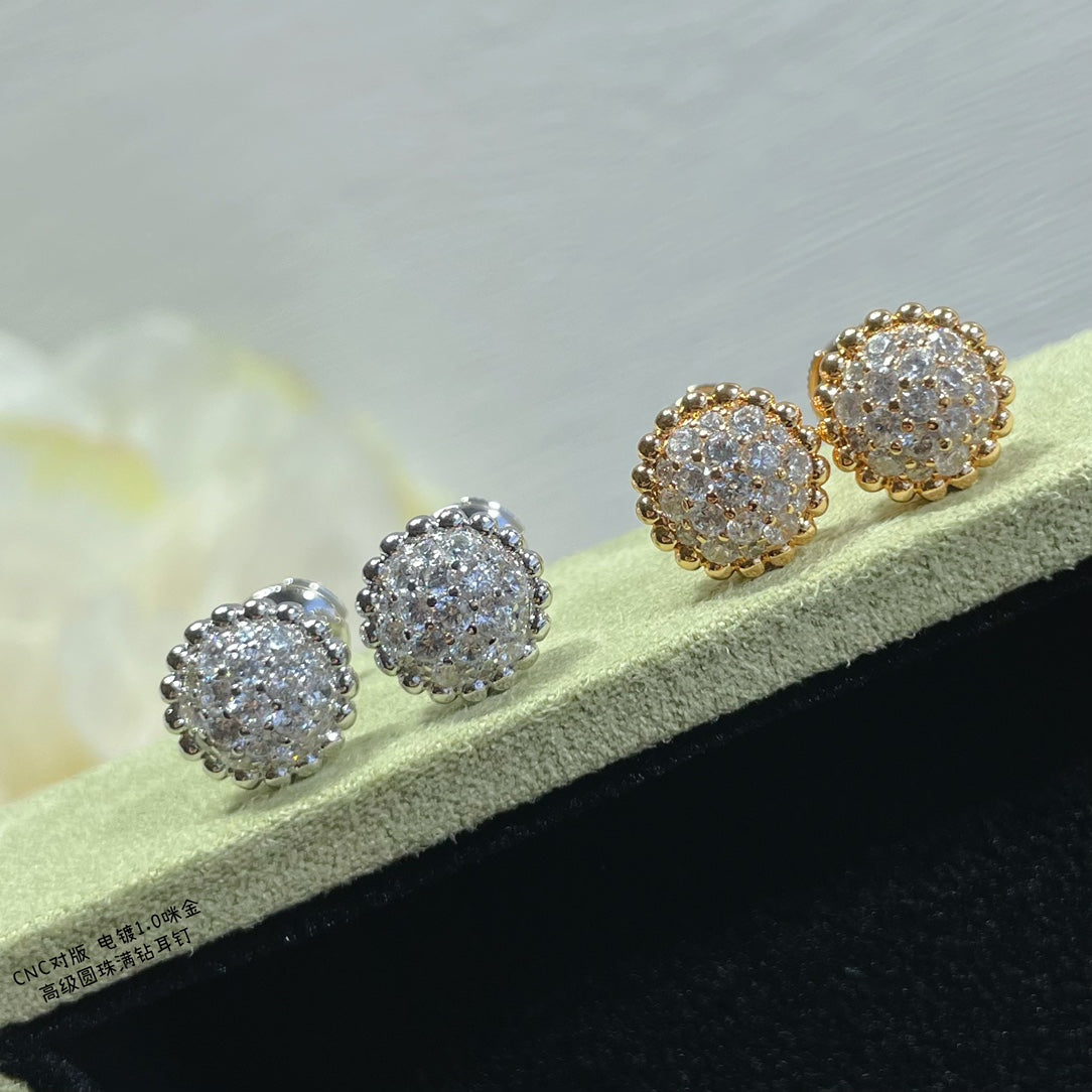 Round cluster stud earrings in gold and silver, arranged on a display bar