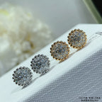 Round cluster stud earrings in silver and gold tones, arranged on a white display