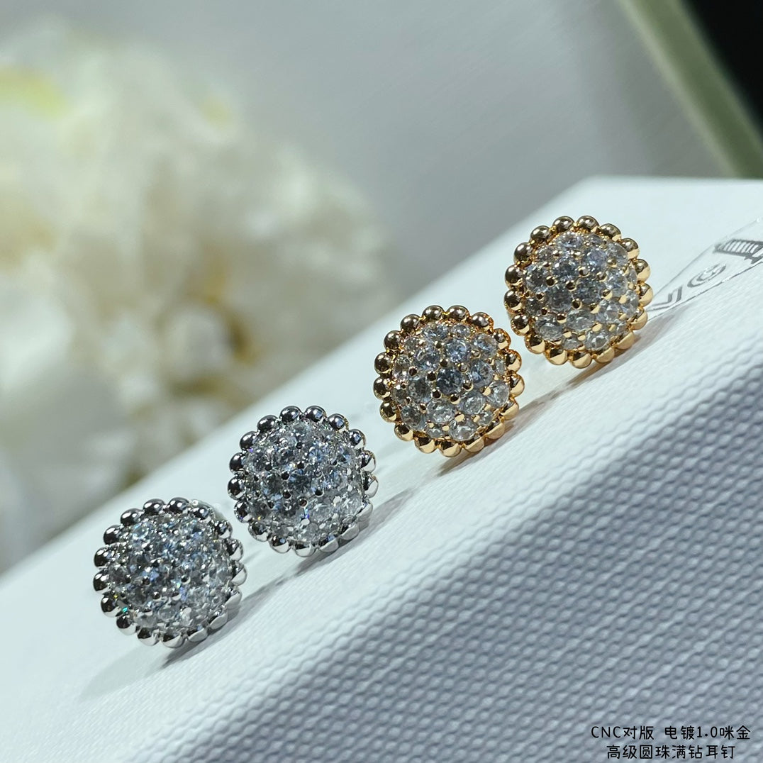 Round cluster stud earrings in silver and gold tones, arranged on a white display
