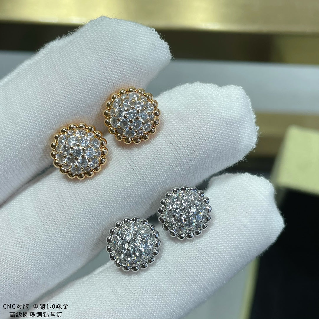 Round cluster stud earrings: gold-toned pair and silver-toned pair held in white gloves