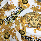 Versace patterned shorts close-up of white fabric with gold faces and VERSACE lettering