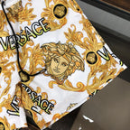 Versace patterned shorts side view in white with gold baroque faces and VERSACE logo