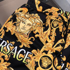 Versace black shorts with gold baroque face print, elastic waistband and side pocket opening