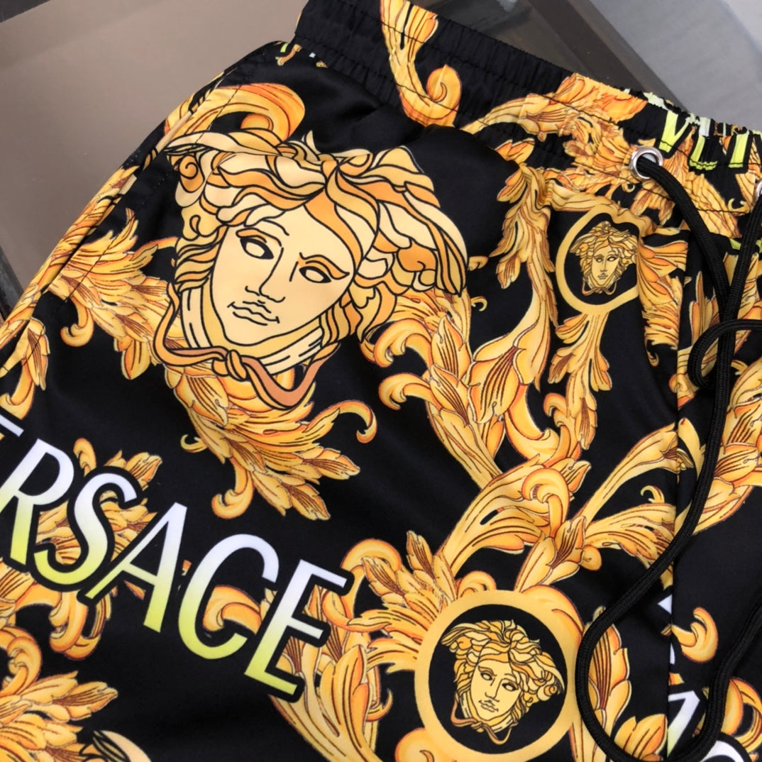 Versace black shorts with gold baroque face print, elastic waistband and side pocket opening