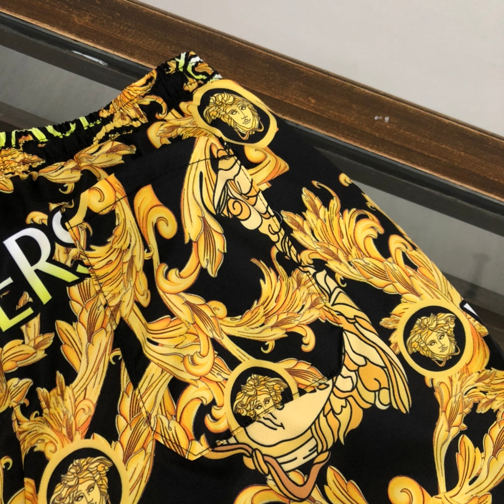 Versace black shorts fabric with gold baroque medusa and scroll pattern close-up