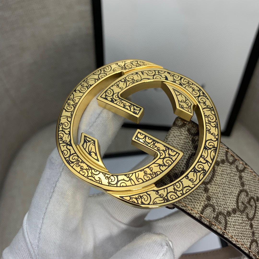 Gucci belt close-up of gold-tone G buckle on GG monogram canvas strap.