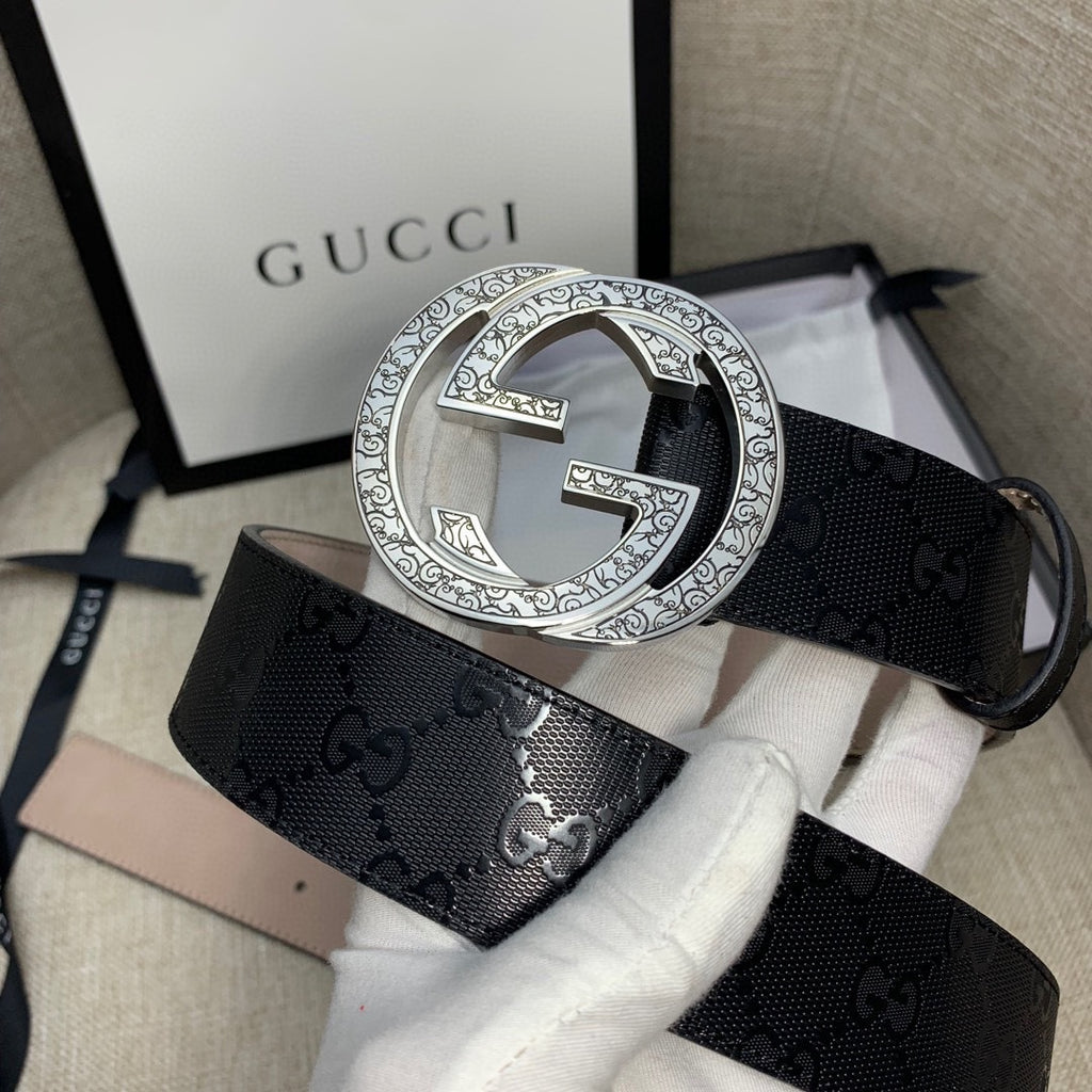 Belt with dark GG canvas and silver double-G buckle, beige underside strap.