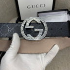 Belt with silver double-G buckle on dark GG canvas strap and tan underside.