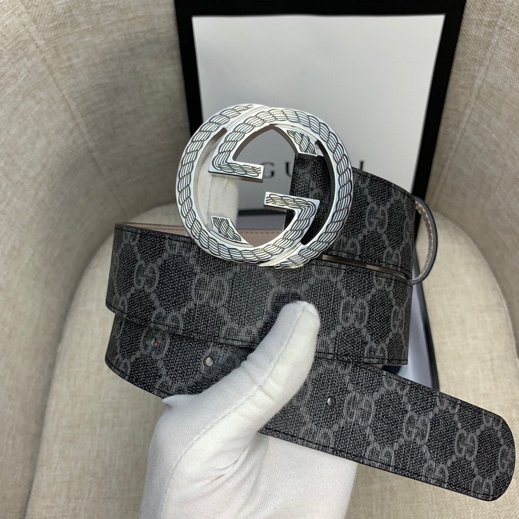 Gucci belt with dark monogram strap and large silver G buckle, angled view.