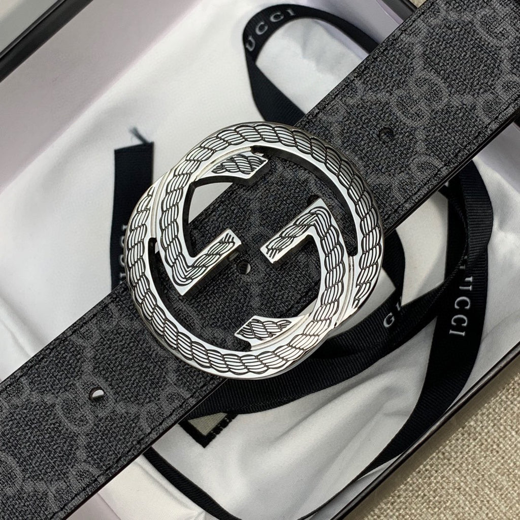 Gucci belt buckle detail on dark monogram strap with embossed G design.