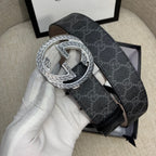 Gucci belt with dark monogram strap and silver G buckle, side angle.