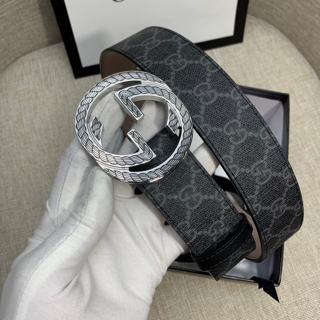 Gucci belt with dark monogram strap and silver G buckle, side angle.