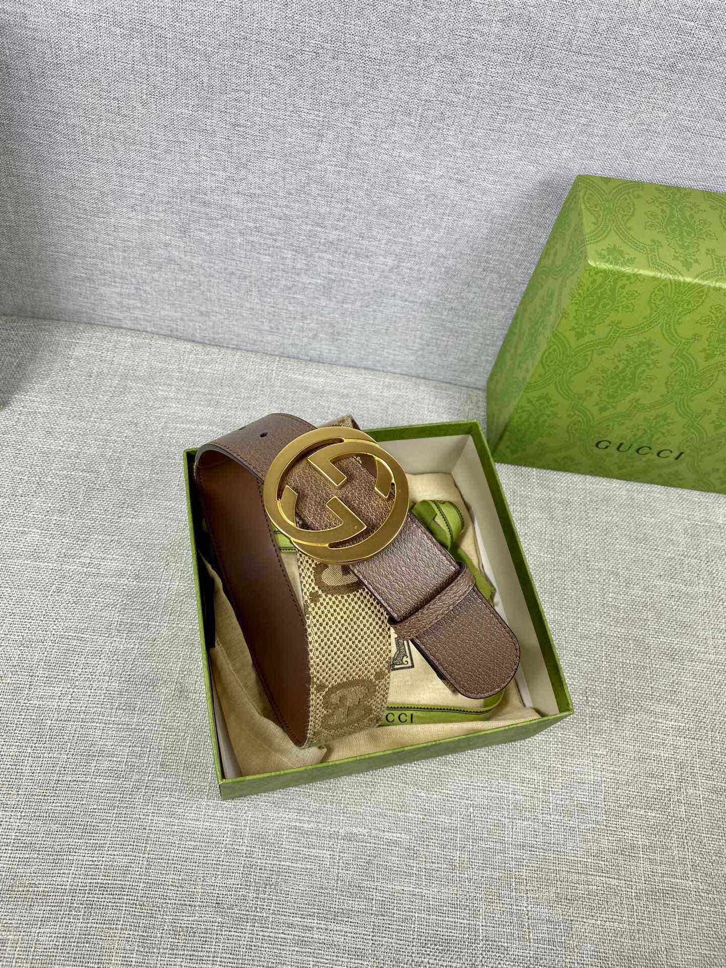 Gucci leather belt with GG canvas strap and gold-tone buckle in box