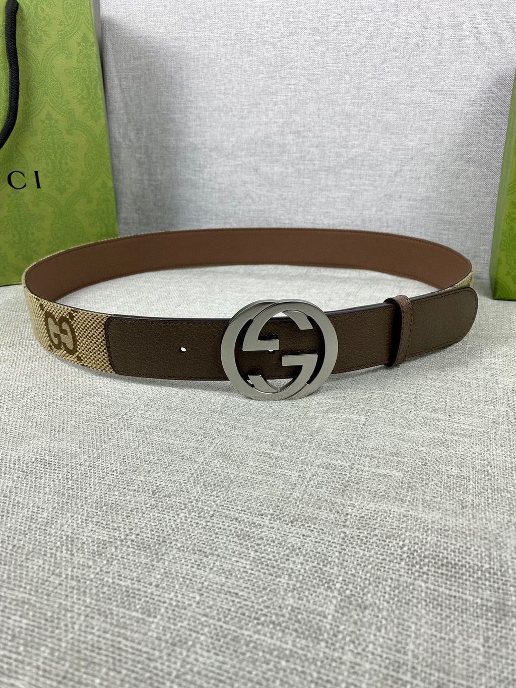 Brown leather belt with GG canvas insert and round silver buckle, laid flat