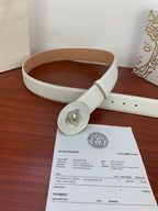 White belt with oval rhinestone buckle laid on table beside receipts