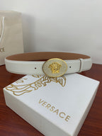 White leather belt with gold oval medallion buckle on Versace gift box