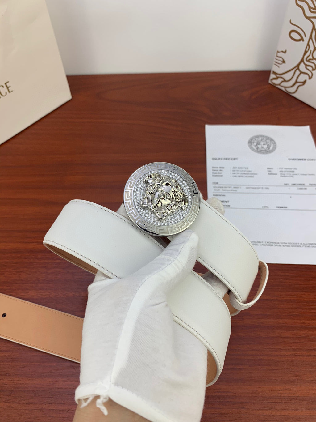 White leather belt with silver Medusa medallion buckle and side eyelet holes
