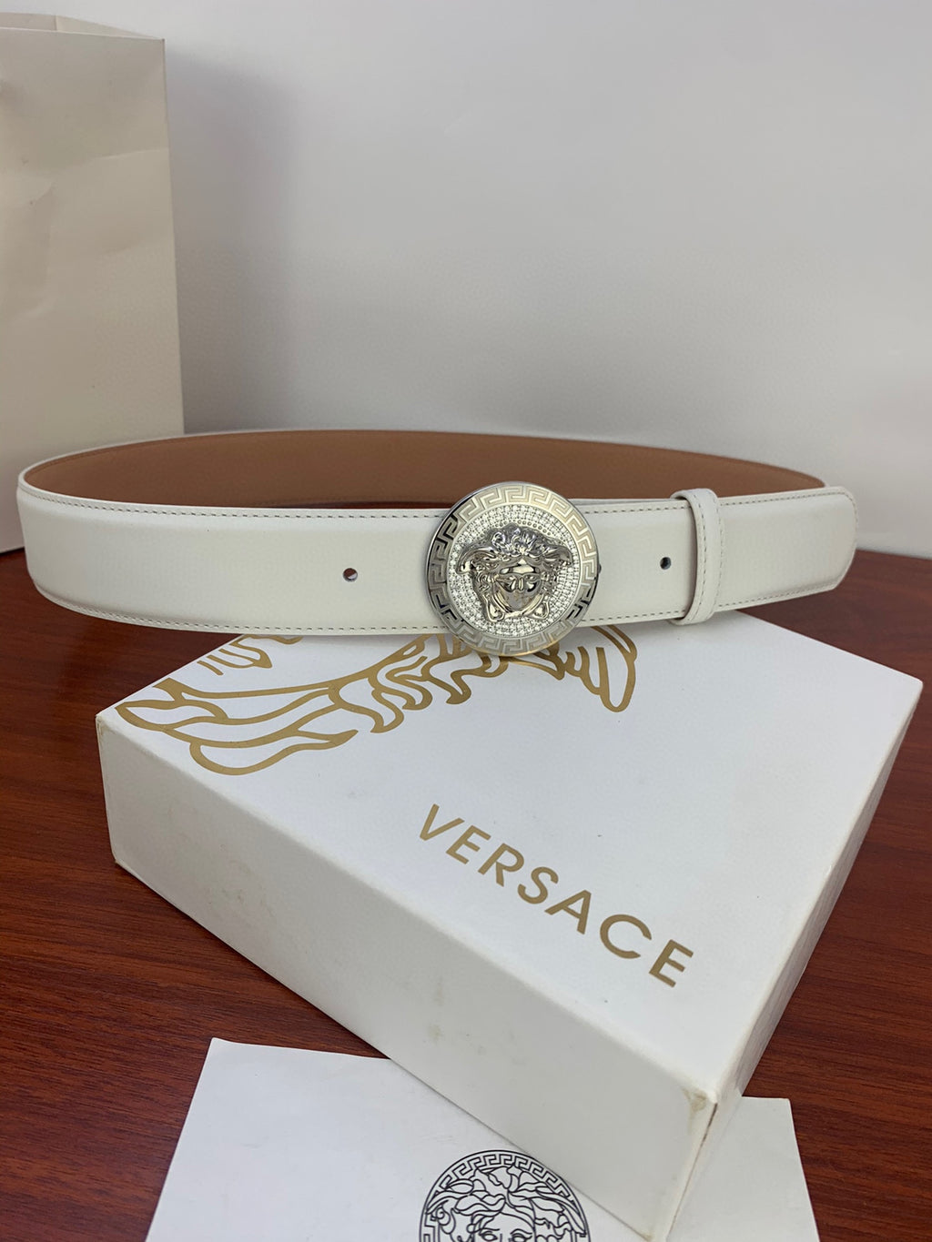 White leather belt with silver Medusa medallion buckle and single row stitching