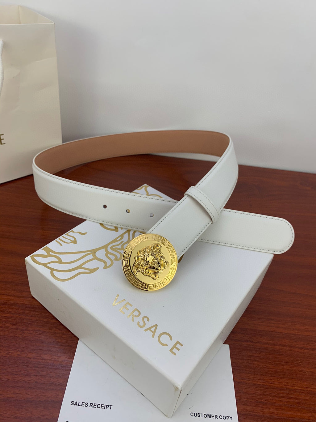 White leather belt with gold Medusa coin buckle and brown inner lining