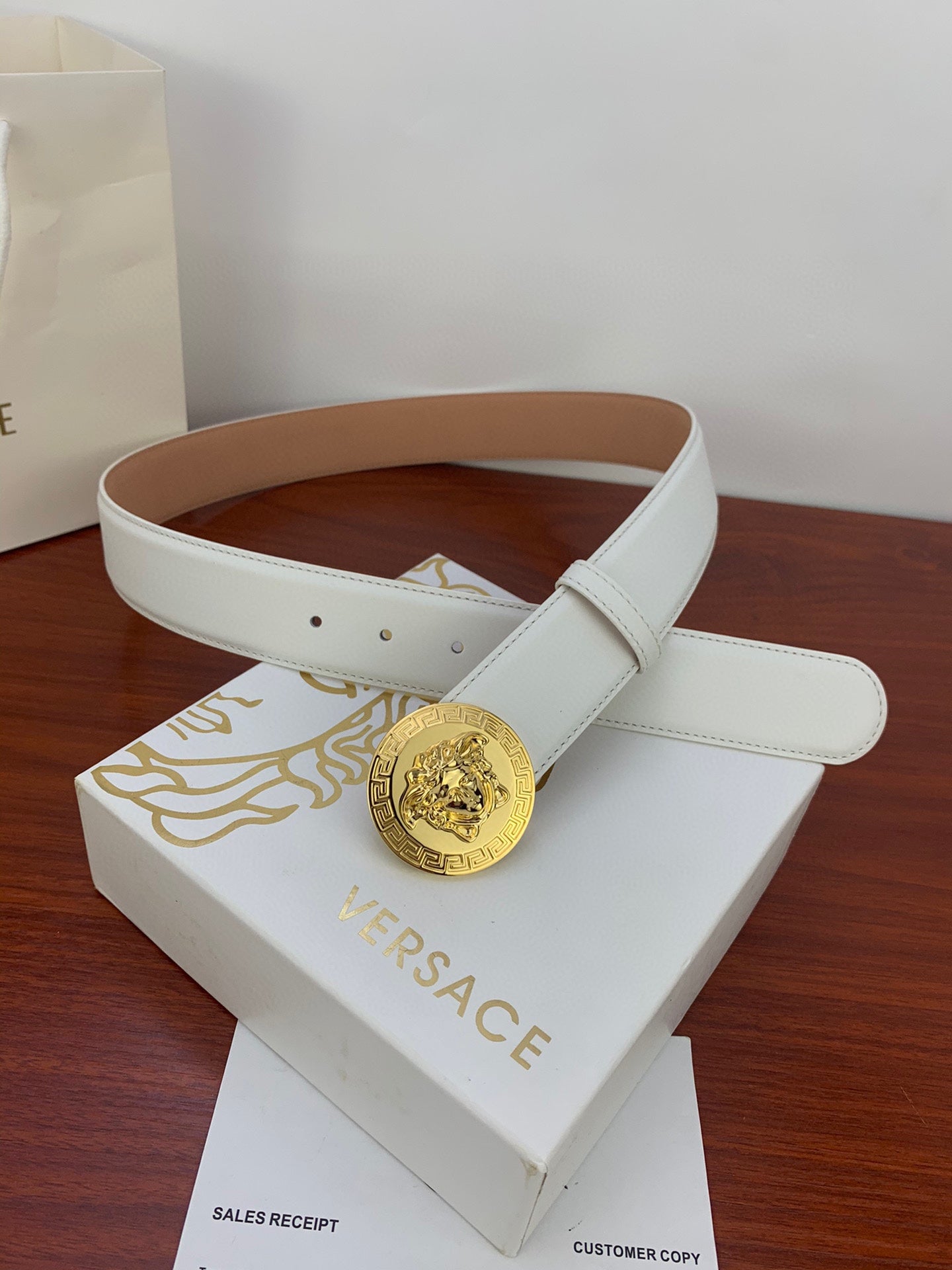 White leather belt with gold Medusa coin buckle and brown inner lining