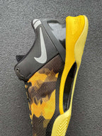 Heel and side of black and yellow camo basketball shoe with swoosh