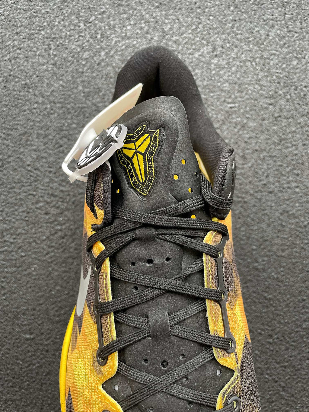 Lace-up black and yellow camo basketball shoe with white logo tag