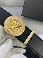 Versace black leather belt close-up with gold medallion lion buckle and trim bar