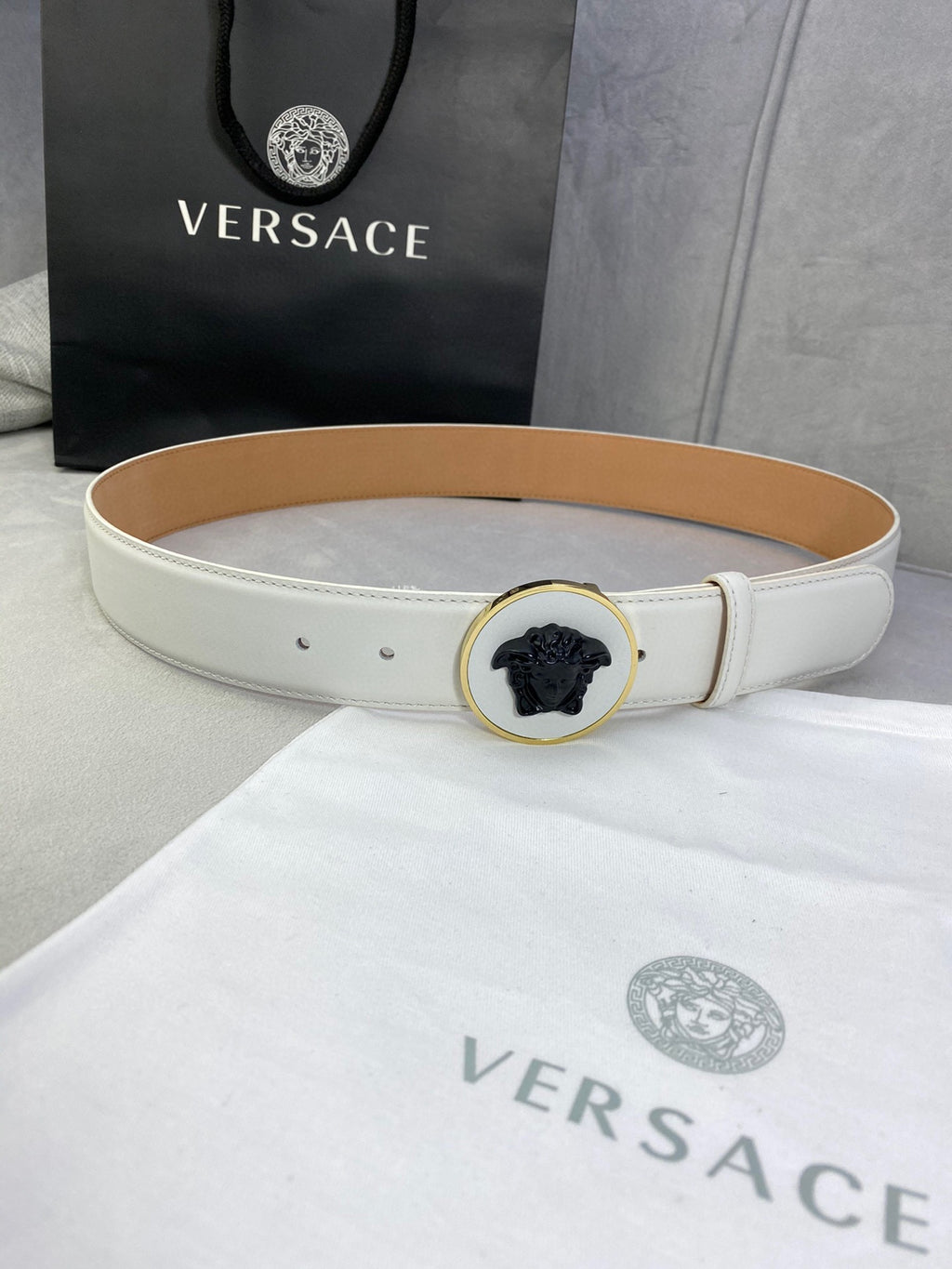 Versace belt in white leather with gold round buckle and black Medusa emblem.