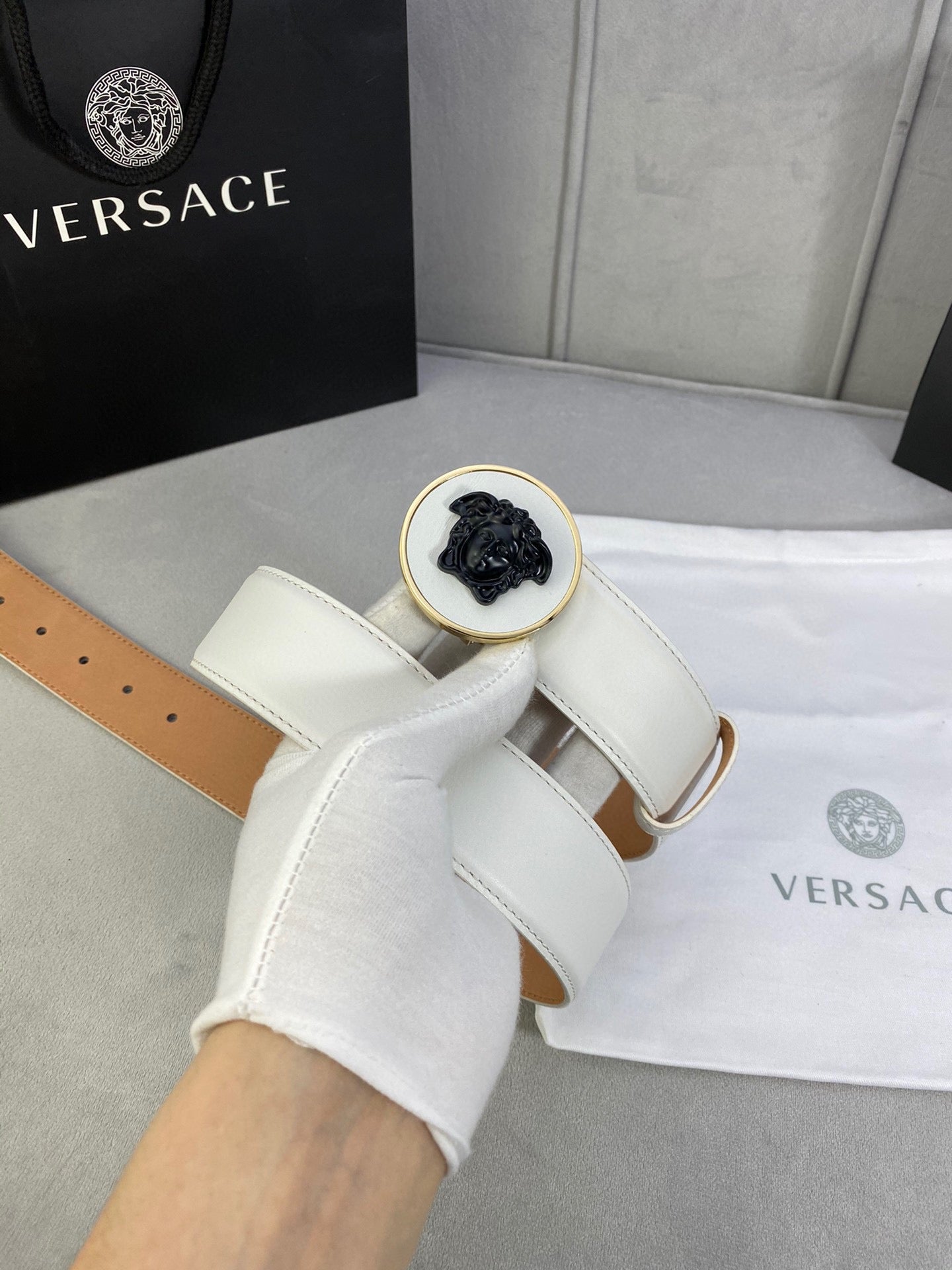 Versace belt, white leather with gold-toned round Medusa buckle and stitched strap.