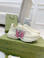 White lace-up sneakers with large pink-and-blue bunny logo on the side