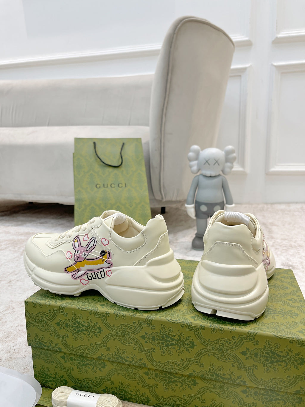 White Gucci lace-up sneakers, one side and heel visible with colorful logo graphic