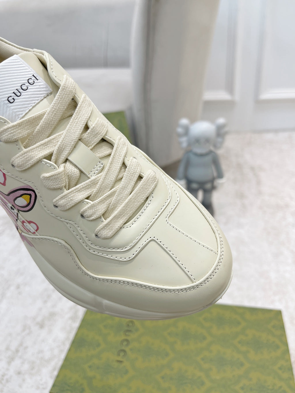 Close-up of white Gucci lace-up sneaker, stitching and side logo graphic details