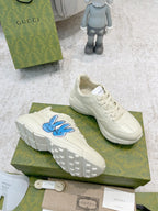White sneakers with blue bunny logo, side profile and sole visible