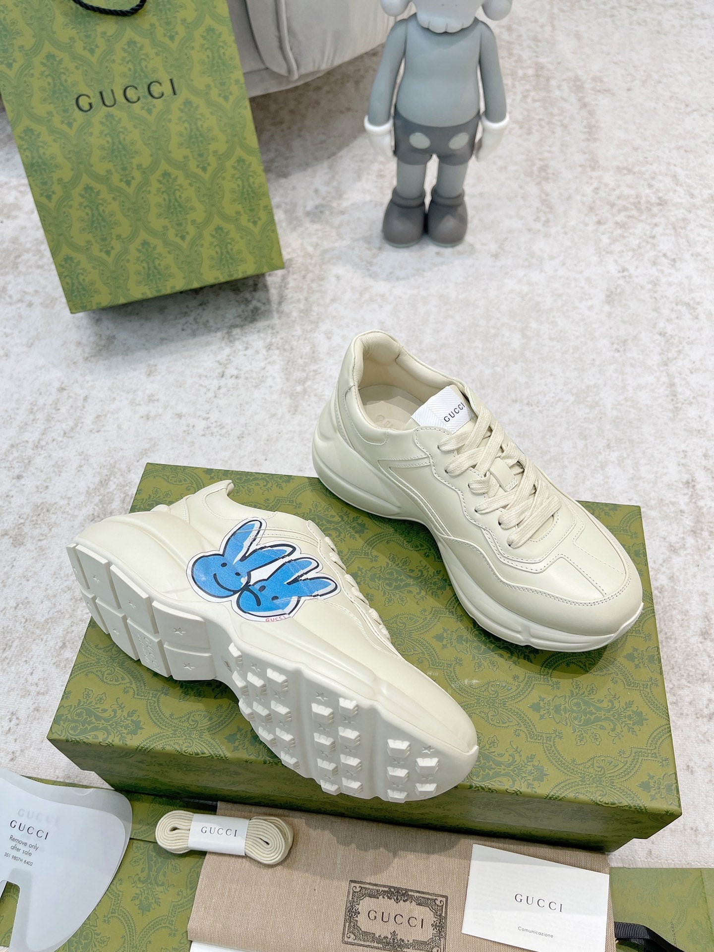 White sneakers with blue bunny logo, side profile and sole visible