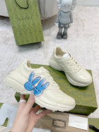 White sneaker with blue bunny logo, lace-up upper shown close-up