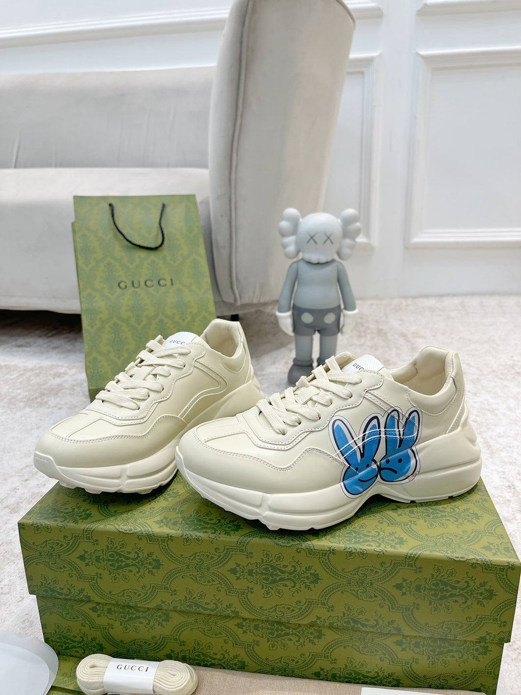 White sneakers with blue bunny logo, front and side views together