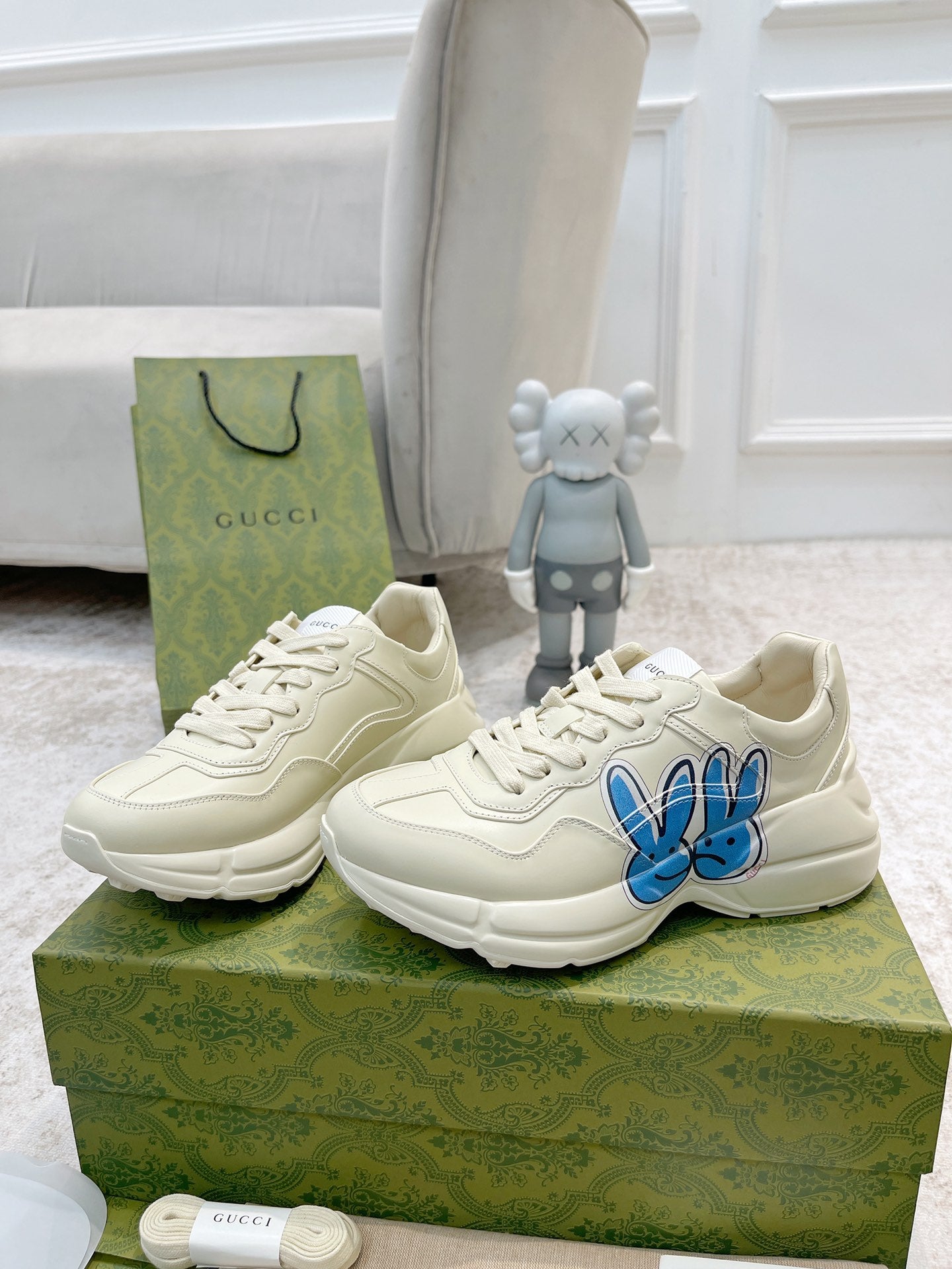 White sneakers with blue bunny logo, front and side views together