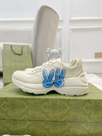 White lace-up sneakers with blue bunny logo on the side, low-top style
