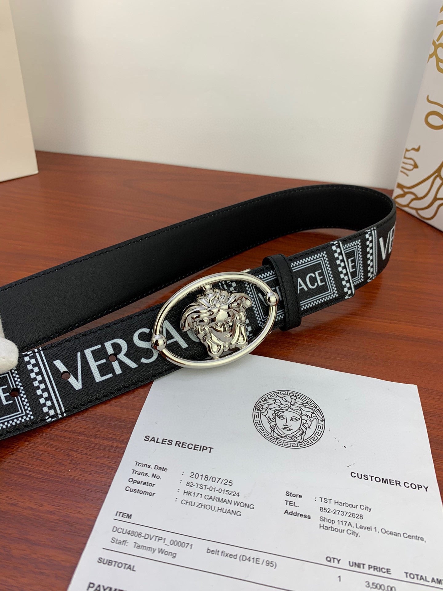 Versace belt laid flat: black leather strap with silver oval buckle