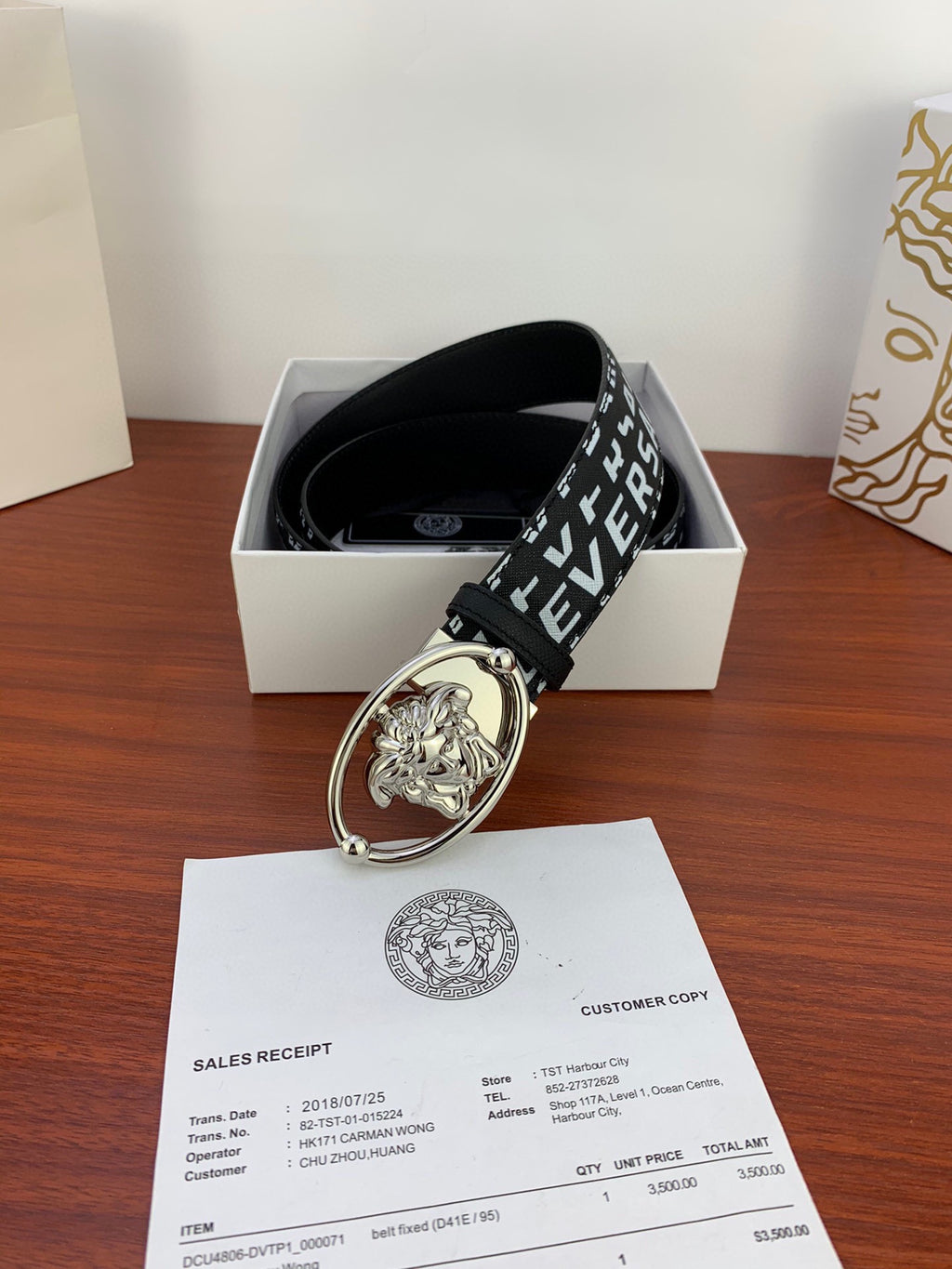 Black Versace belt with repeating white logo and silver Medusa oval buckle in box