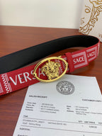 Versace belt with red and black construction, gold Medusa oval buckle, and logo webbing.