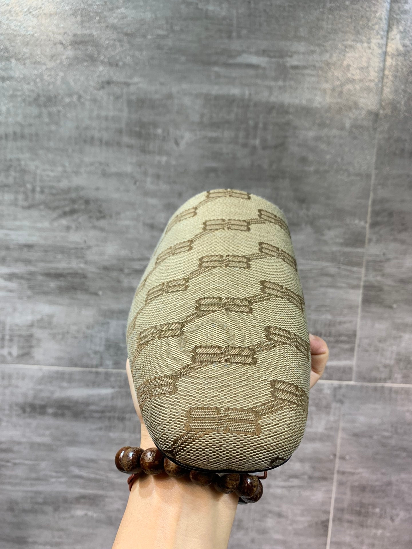 Single beige patterned slide sandal, front toe and stitched texture close-up