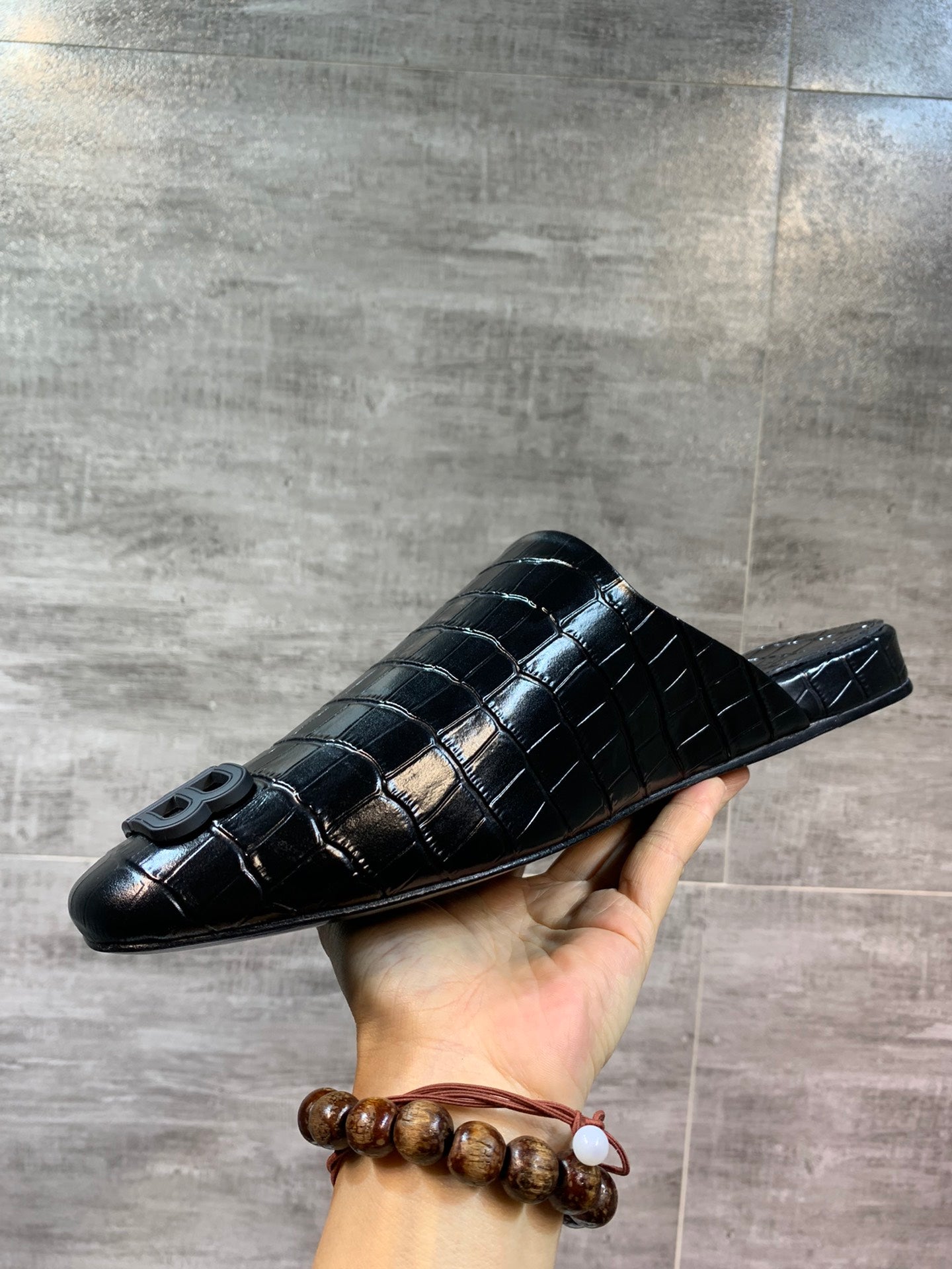 Black croc-embossed slide sandal with BB logo, front view held up