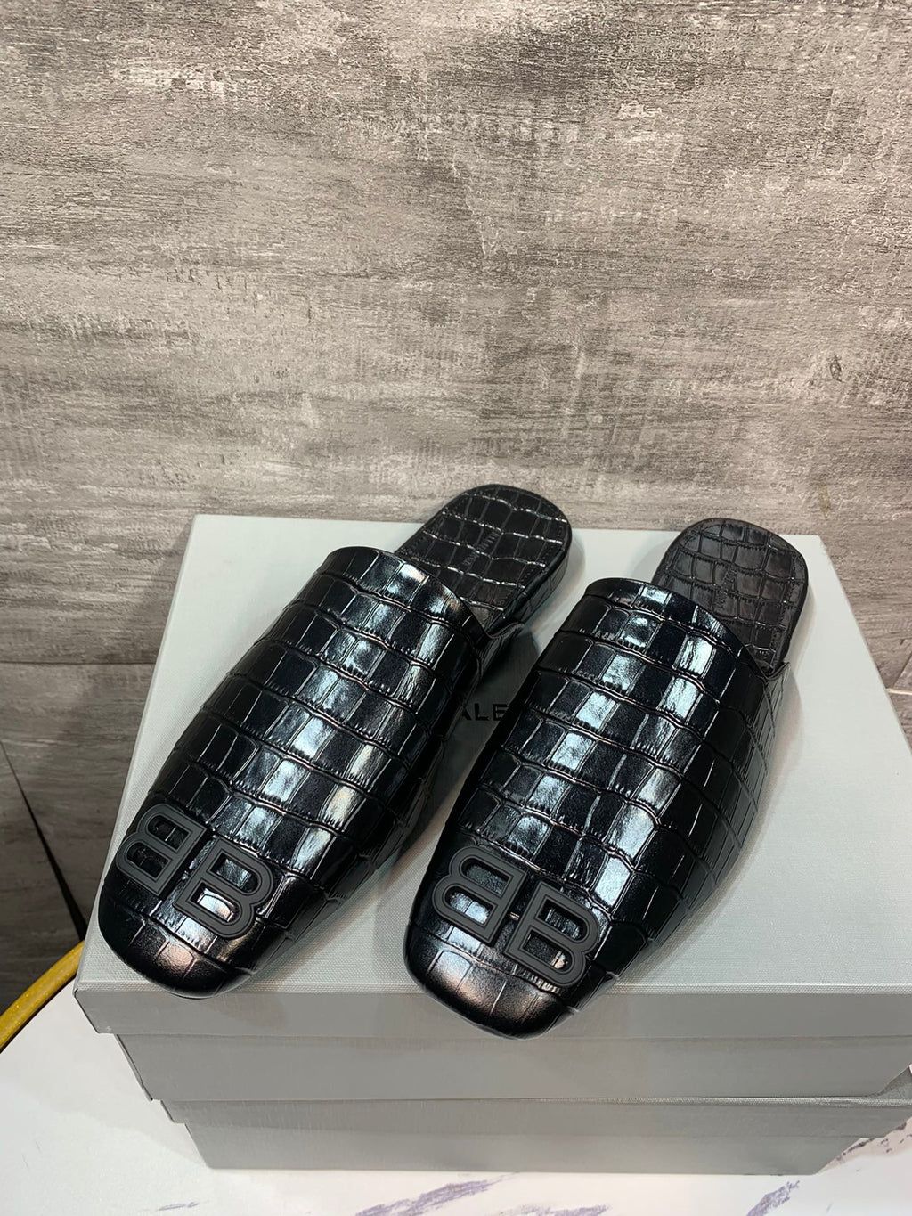 Black croc-embossed slide sandals pair with BB logo on top strap