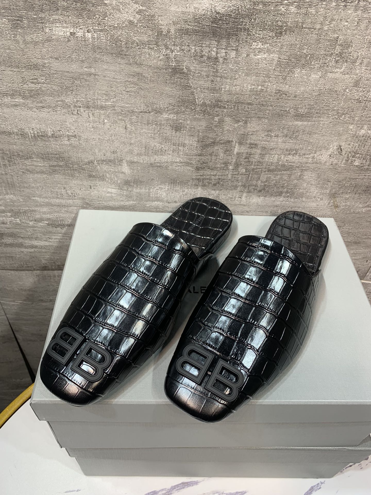 Black croc-embossed slide sandals pair with BB logo on top strap